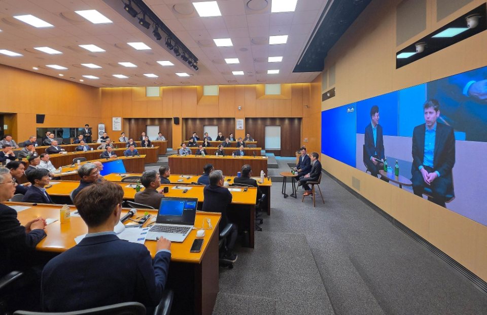 31 Ekim 2026’daki Yongin toplantısında Samsung yöneticileri Sam Altman’ı dinliyor; salonun sağındaki ekranda konuşmanın görüntüsü yer alıyor.