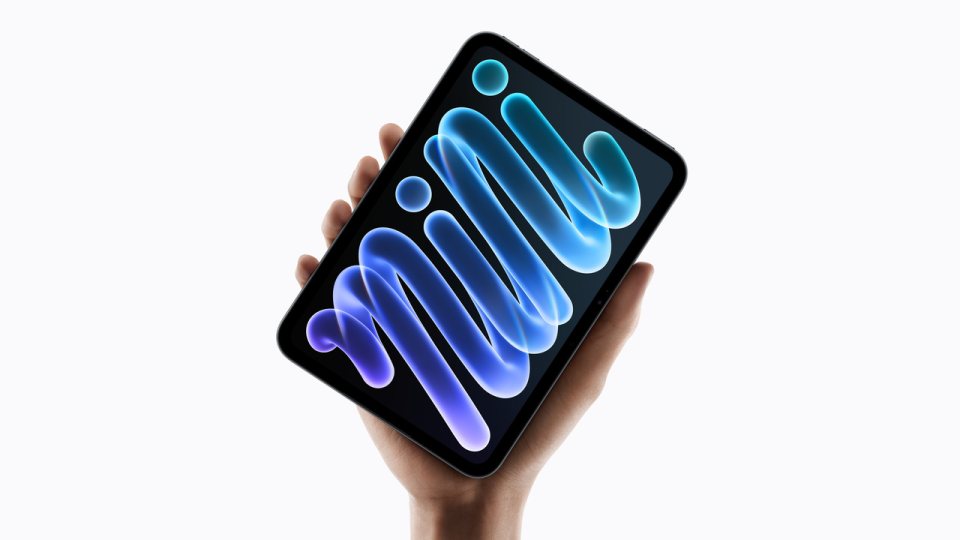 Apple’ın 2026 model iPad mini 8’i bir elde dikey tutuluyor; ekranında mavi desenli duvar kağıdı açık.